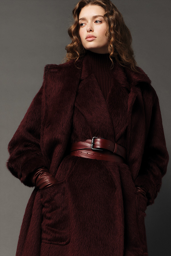 Max Mara Fall/Winter 2025 Fashion Show - Model with Cherry Look with Long Coat, Sleeveless Coat, Belt and Leggings.